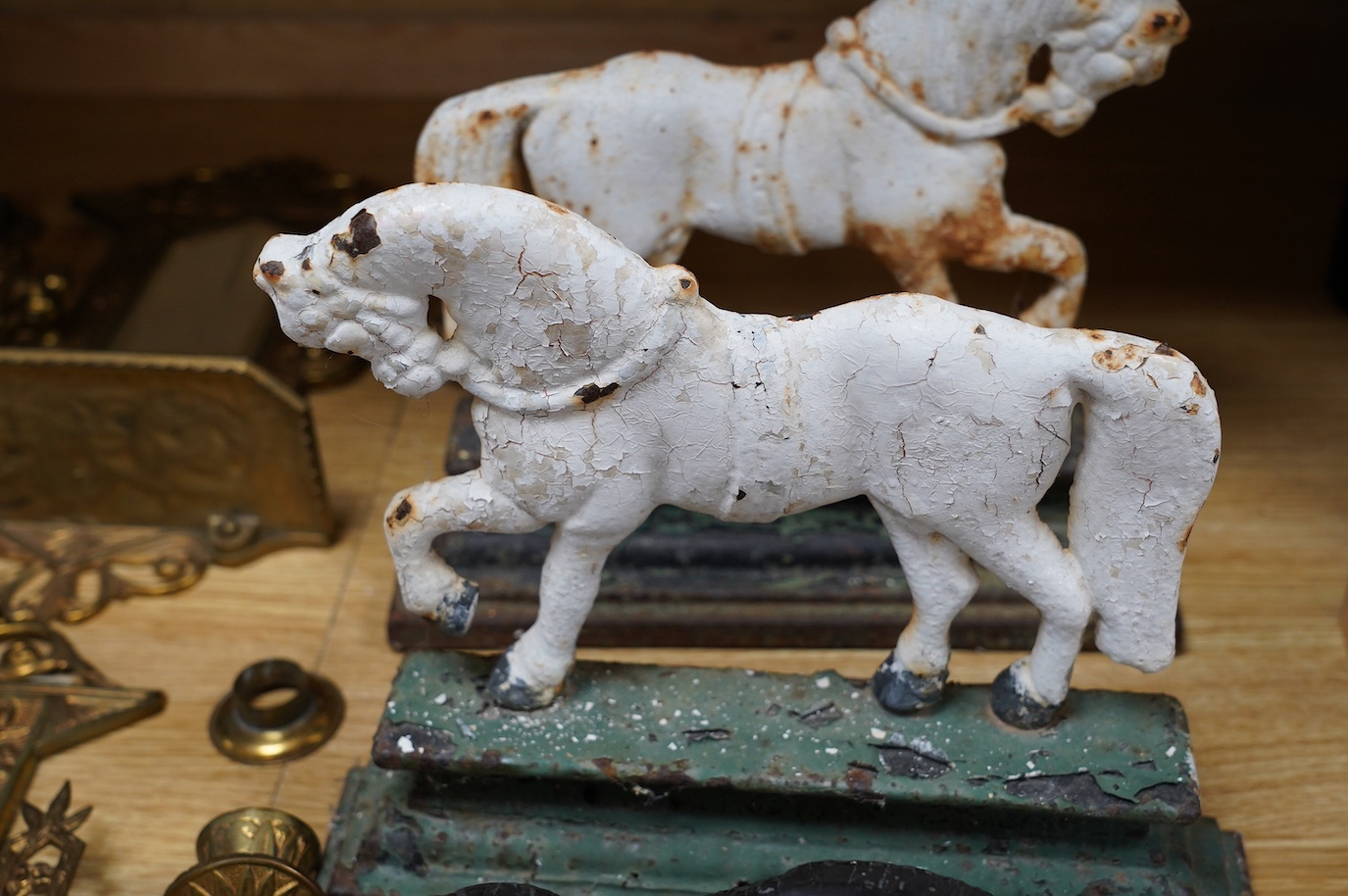 A Chinese spelter model of a tiger on hardwood plinth, a pair of Victorian painted cast iron ‘horse’ door-stops and a pair of brass two branch wall sconces, 37cm. Condition - fair